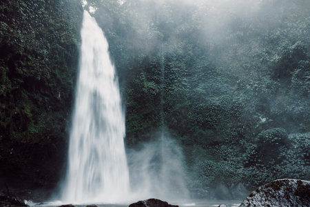 Nungnung Waterfall with powerful flow in Bali, Indonesia. Tropical nature and epic waterfallの写真素材
