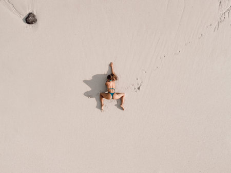Aerial view of sexy slim woman in bikini on sandy beach.の写真素材