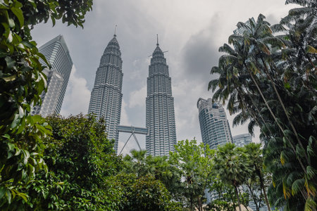 May 25, 2024. Kuala Lumpur, Malaysia. Park and Kuala Lumpur skyscrapers on sunny day. Twin towers in KL center.のeditorial素材