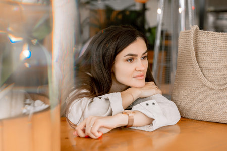 Portrait of dreaming young attractive woman in cafeの写真素材