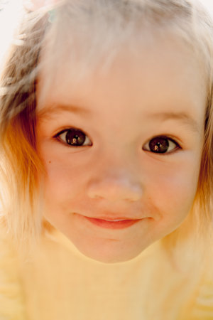 Close up portrait of cute child girl in yellow dress