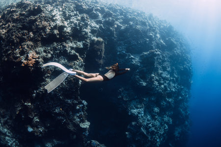 Female freediver swims underwater near reef in Menjangan, Bali.の写真素材