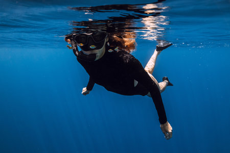 Female freediver snorkeling in tropical blue sea in Bali.の写真素材