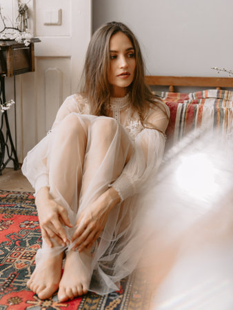 Young caucasian fashionable woman wearing stylish bridal dress posing in vintage interiorの写真素材