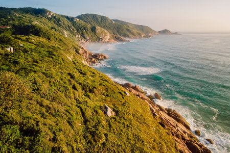 Scenic coastline with rocks and ocean with waves at warm sunrise. Aerial viewの写真素材
