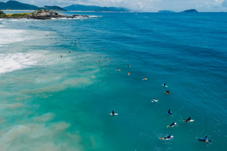 Surfers on surfboards in blue ocean waiting wave in Floripa. Aerial view in Brazilの写真素材