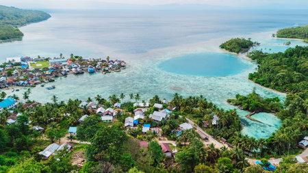 Ocean coastline with blue lagoon, tropical landscape and local village in Indonesia. Above drone viewの写真素材