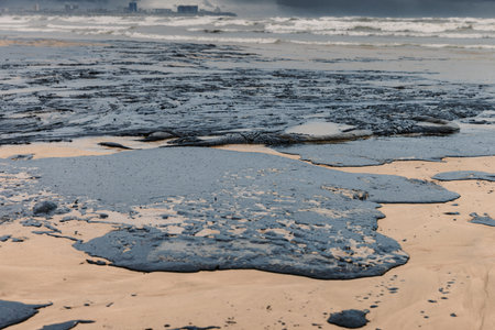 Oil leak in sea coastline after a tanker wreck. Fuel oil polluted beach. Ecological catastropheの写真素材