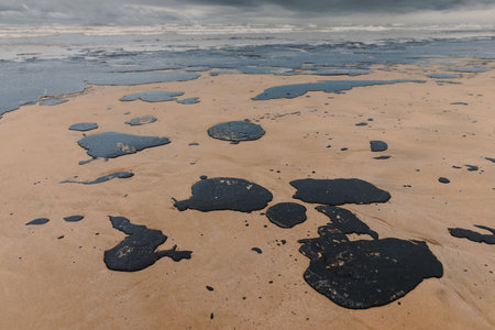 Oil leak in ocean coastline after a tanker wreck. Fuel oil polluted and destroying beachの写真素材