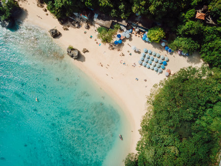 Padang padang beach with umbrellas and turquoise ocean. Summer vacation in Bali. Drone shotの写真素材