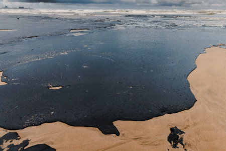 Oil in coastline after a tanker wreck. Fuel oil leak and polluted beach