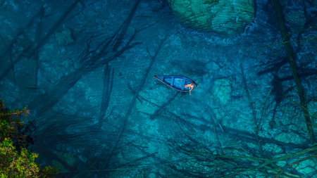 Woman on boat in transparent blue lake with crystal water in Indonesia. Aerial viewの写真素材