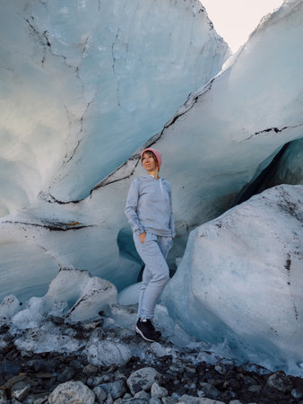 Hiker woman staying under big ice glacier. Glacier and female touristの写真素材