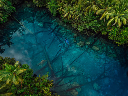 Boat in transparent blue lake with crystal water in tropics. Aerial viewの写真素材