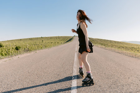 Attractive brunette young woman roller skating outdoorの写真素材