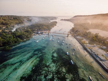 Drone view of a bridge connecting two tropical islands over a narrow ocean channel. Nusa Lembongan and Nusa Ceningan bridge.の写真素材