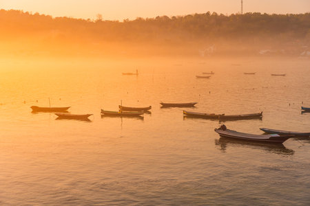 Lagoon with warm morning sunlight at Lembongan island. Boats, sunlight and fogの写真素材