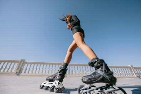 Low angle view of woman rollerblading on sunny dayの写真素材