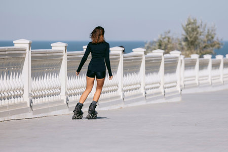 Sporty woman rollerblading outdoors in black sportwear, active lifestyleの写真素材