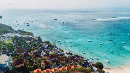 Nusa Lembongan island with tropical beach coastline and turquoise ocean with boats, drone viewの写真素材