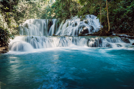 Scenic cascade waterfalls with blue water in tropical forest, long exposure