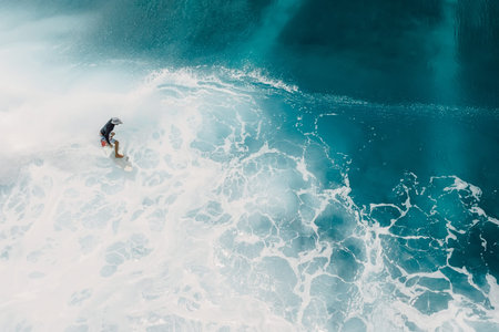 January 25, 2026. Bali, Indonesia. Aerial view with surfing on ideal wave. Perfect waves with surfer...