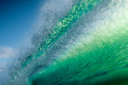 Crystal green wave crashing under blue sky, dynamic surf texture