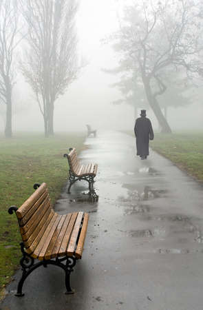 A orthodox priest walking towards foggy background.の写真素材