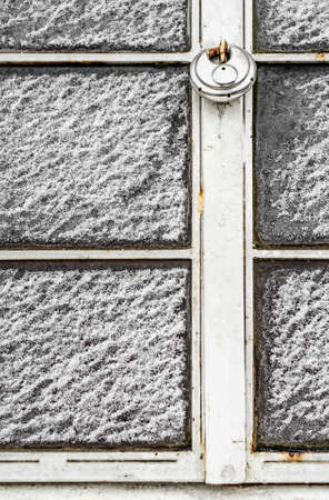 Locked window covered with snow.の写真素材