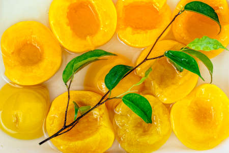 A group of canned peach halves in light syrup.の写真素材