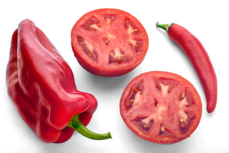 Ripe red vegetables on a white background: Paprika, chilli pepper and halved tomato.の写真素材
