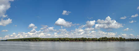 Panoramic image of beautiful blue Danube. Trees are on the other side of the river. Made from several frames stitched together to achieve very high resolution.の写真素材