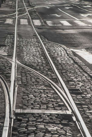 Tramlines crossing on a cobblestone background during sunrise.の写真素材