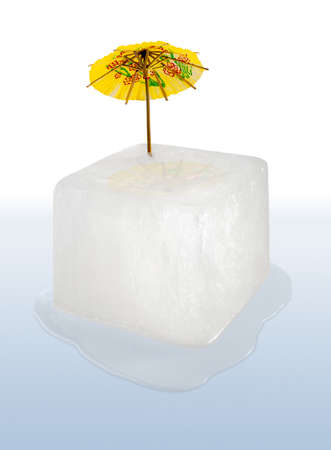 Ice Cube with yellow paper cocktail umbrella. Global Warming Concept.の写真素材