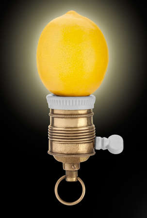 Imaginary lemon bulb, mounted in vintage brass/porcelain socket, glowing on black background. Useful for eureka concept.の写真素材