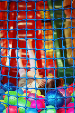 Happy girl enjoying in the safe playground with multi coloured balls.の写真素材