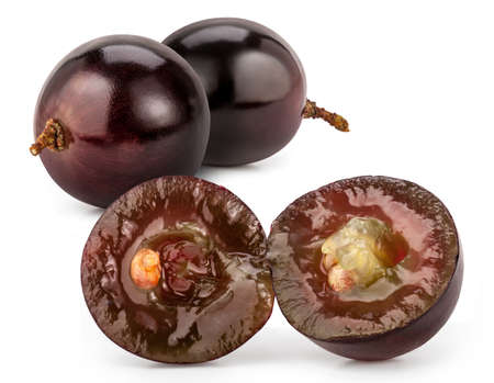 Two whole and one cut in half berry of red grapes. Macro shot of juicy grapes isolated on white background.の写真素材