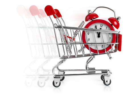 Shopping cart with alarm clock in it and moving blur behind. Concept of last minute shopping.の写真素材