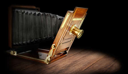 Beautifully crafted, vintage wood and brass studio camera on dark rustic wooden background.の写真素材