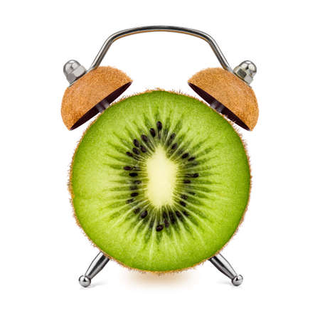 Cut Kiwi as an alarm clock on a white background. Healthy time concept.の写真素材