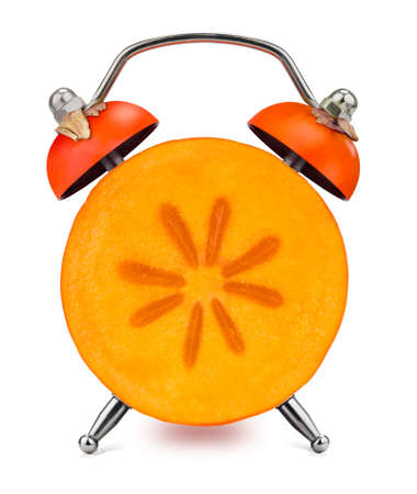 Cut Japanese persimmon as an alarm clock on a white background. Healthy time concept.の写真素材