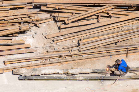 Male construction worker cutting iron scrap parts with acetylene torch.の写真素材