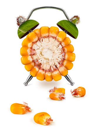 Cross-section of the corn as an alarm clock, with few scattered seeds, on a white background. Healthy time concept.の写真素材