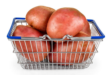 Large red potatoes (Solanum tuberosum) in a shopping basket, isolated on white.の写真素材
