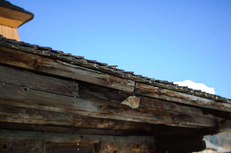 Spring thaw. Drops with old wooden roof.
