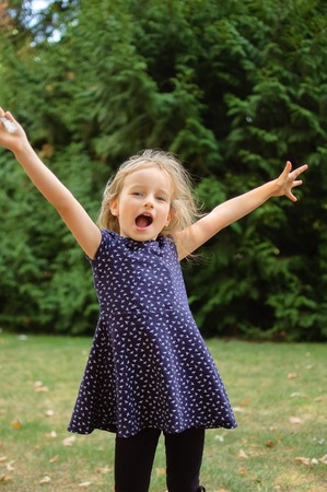 Outdoors Portrait of Happy Acive Female Child Screaming in the Park During Summer Dayの写真素材