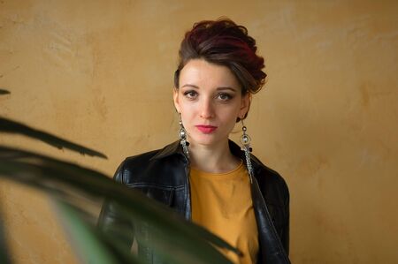 Glamorous lady in punk rock style party clothes with dark pink hair in casual dress, black leather...