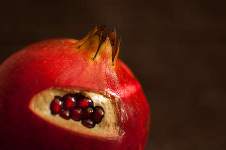 Juicy garnet, ripe pomegranate fruit on wooden background.の写真素材