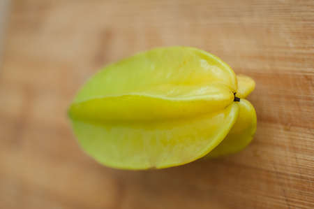 Exotic starfruit or averrhoa carambola on wooden cut board. Healthy food, fresh organic star apple fruit.の写真素材