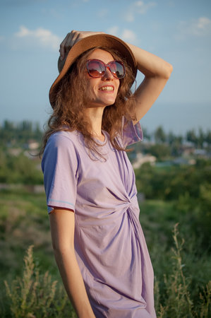 Young girl in dress is having great time during vacation in the summer on sky background in nature, travelling conceptの写真素材